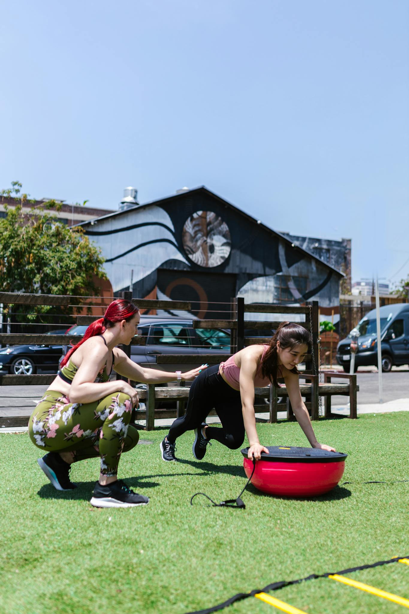 Women engaging in an outdoor fitness routine using balance equipment.